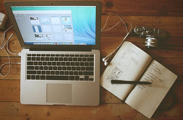Laptop on Desk with Journal and IPod Earpieces
