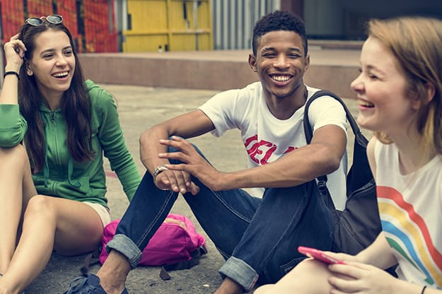 Three Teens Sitting, Laughing Together